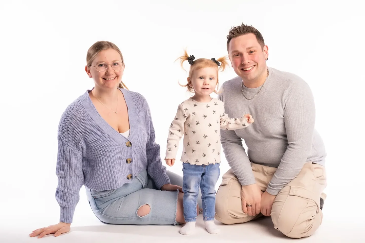 Familie mit kleinem Kind vor hellem Studiohintergrund